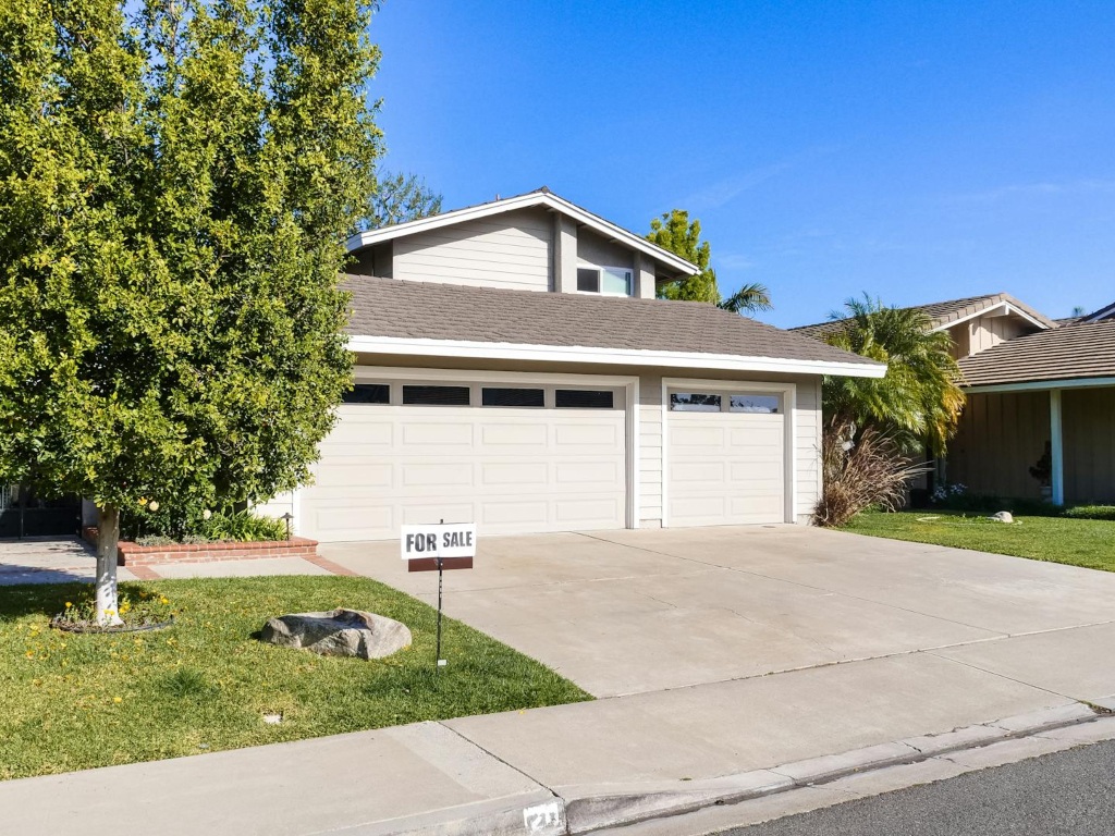 "For Sale" sign in front of a house