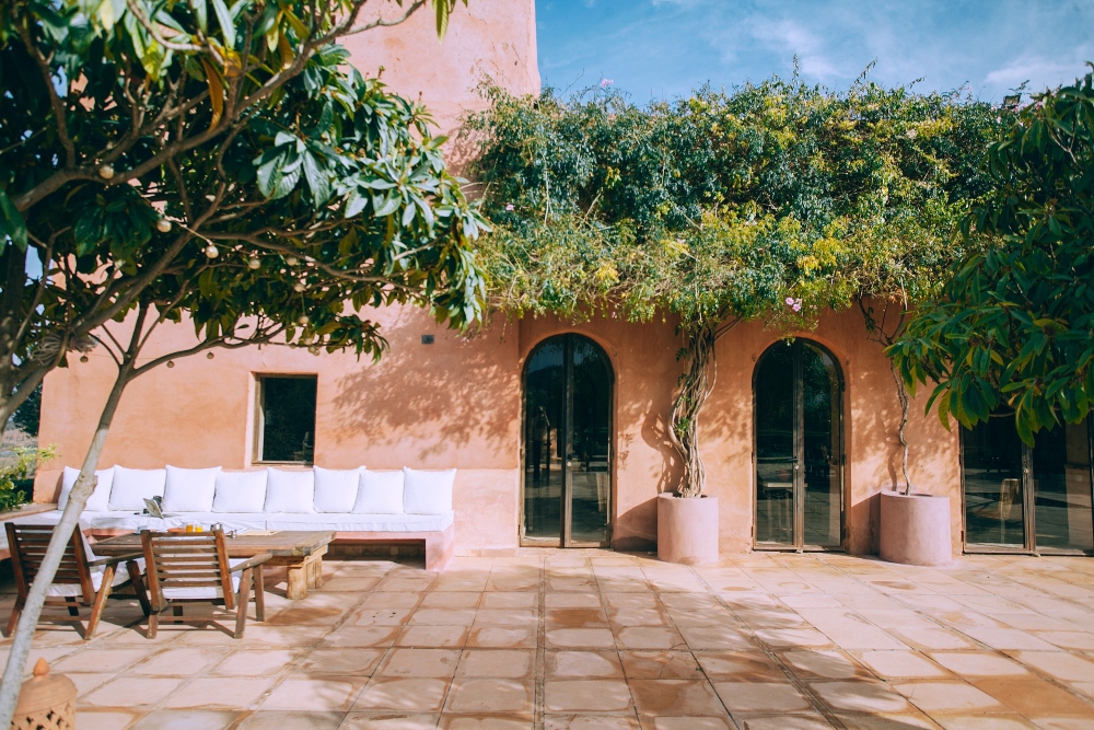 An outdoor patio with a wooden table and chairs