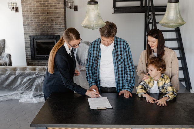 A man with his wife and a child signing a contract