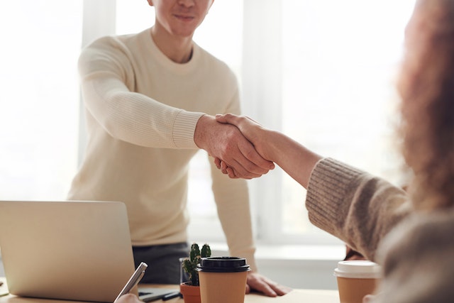 A home inspector shaking hands with a house seller.