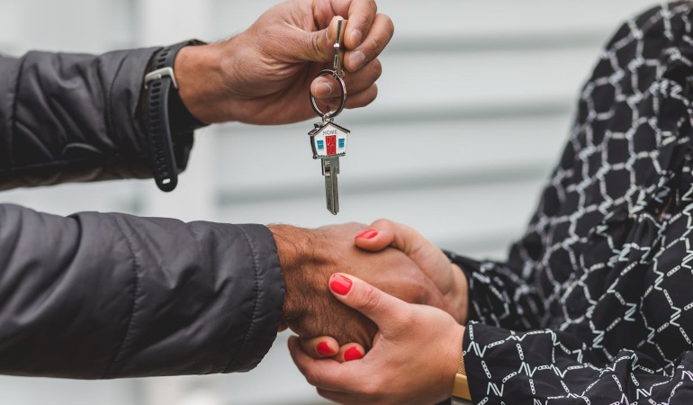 One person handing a home key to another